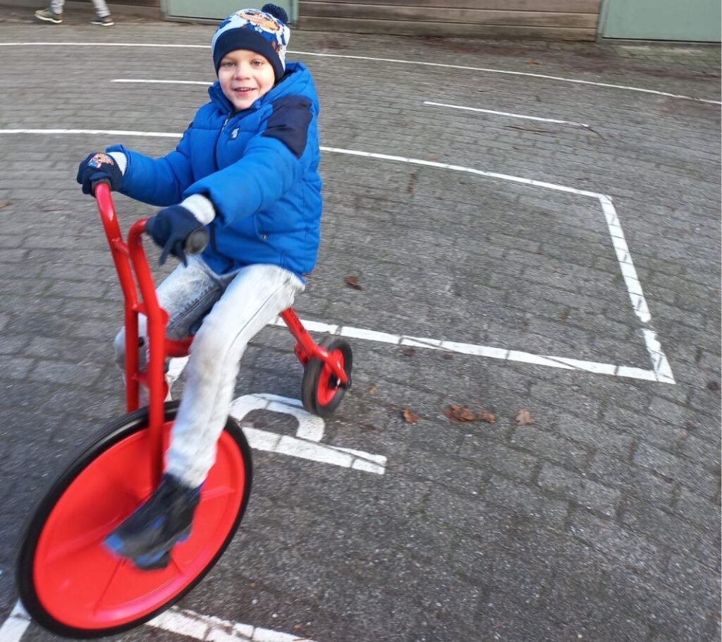 Foto van kindje op een aangepaste fiets om zo te leren fietsen_Goodwill.nl